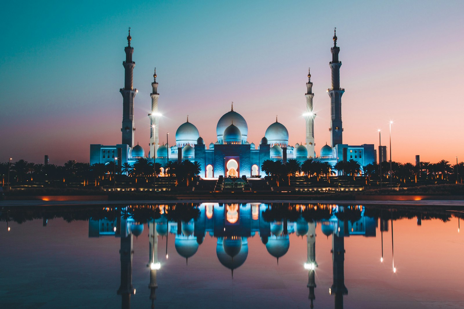 Grande mosquée Cheikh Zayed d'Abu Dhabi se reflétant dans un bassin au coucher du soleil
