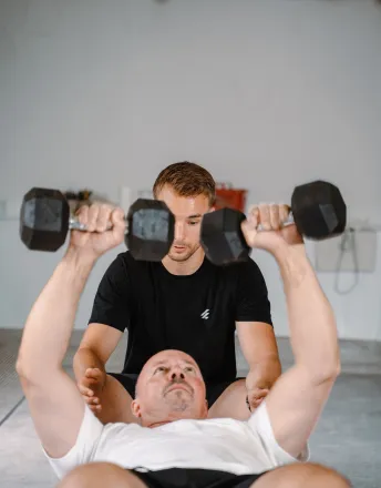 Benedikt unterstützt einen Klienten beim Personal Training