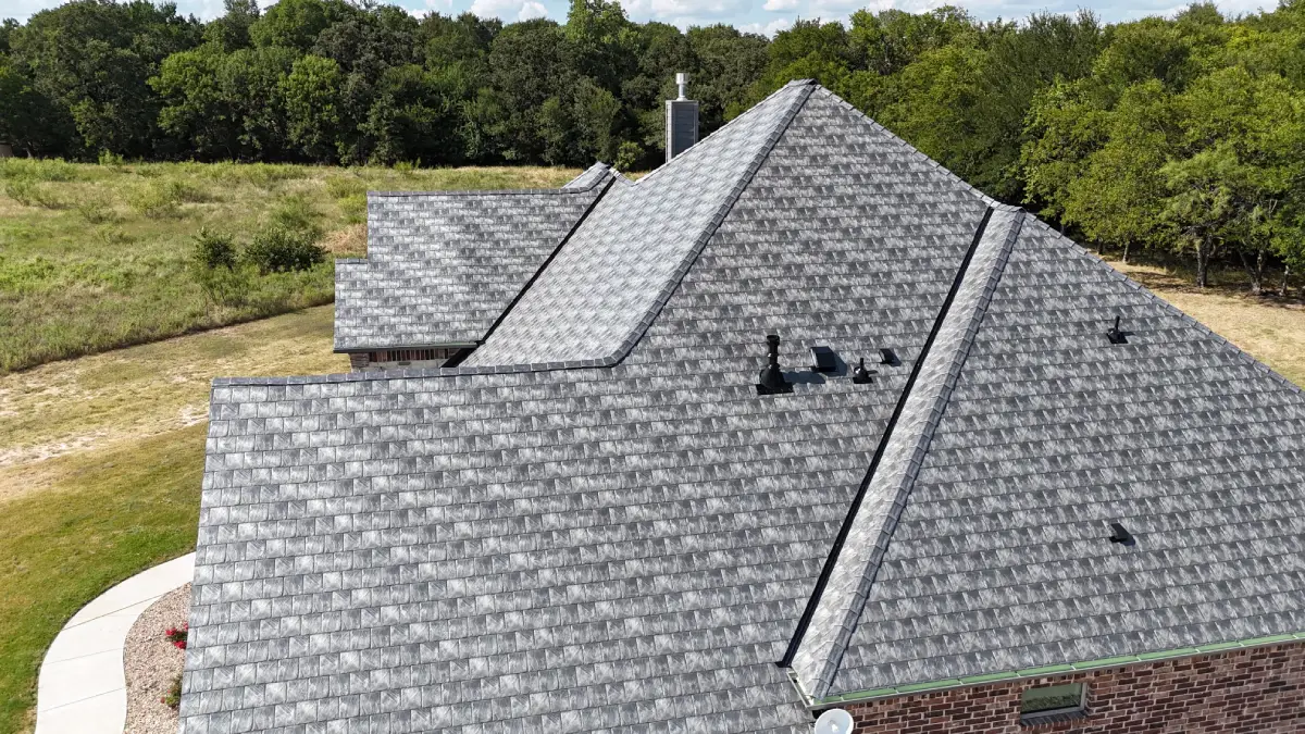 Aerial view of a house with Euroshield shingles surrounded by a grassy area and trees.