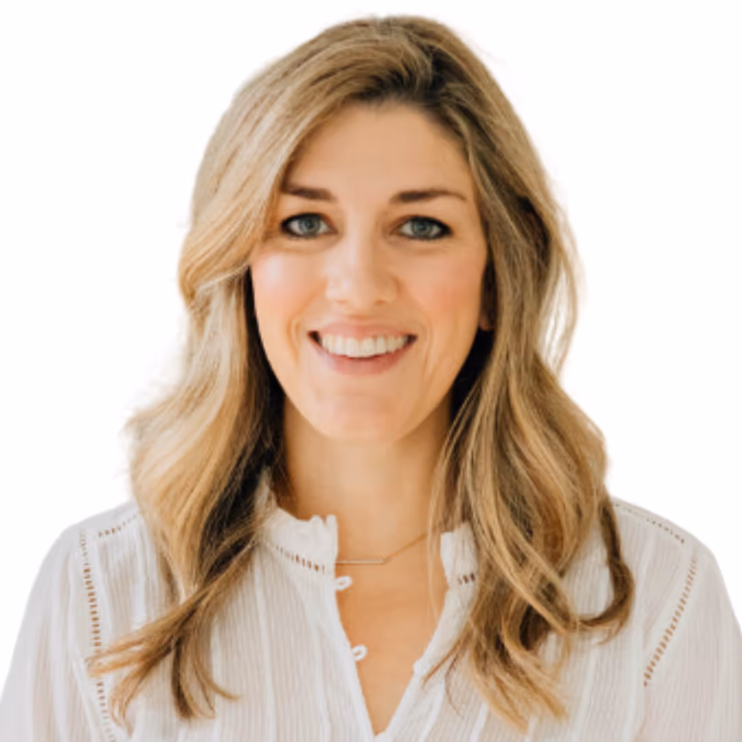 Smiling woman with long wavy blonde hair wearing a white blouse on a white background.