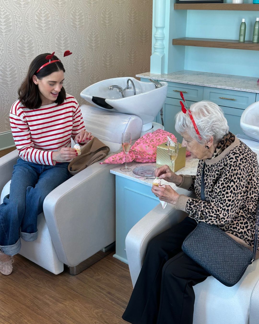 A senior resident enjoys a cupcake and conversation with a Symphony Park staff member at the Galentine's Day celebration. 