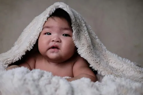 Baby under a fleece blanket