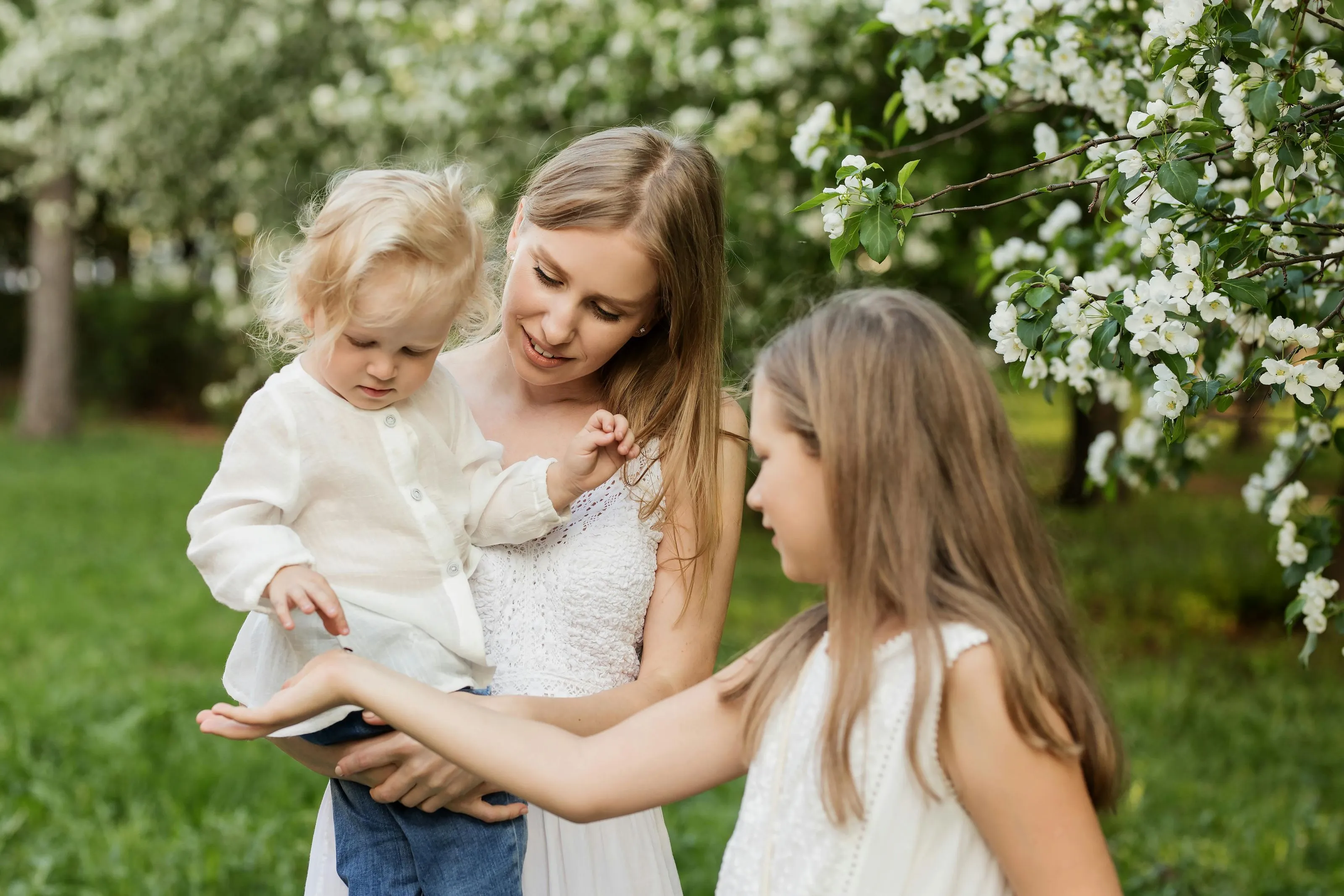Mother with her 2 daughters in front of a flowering tree