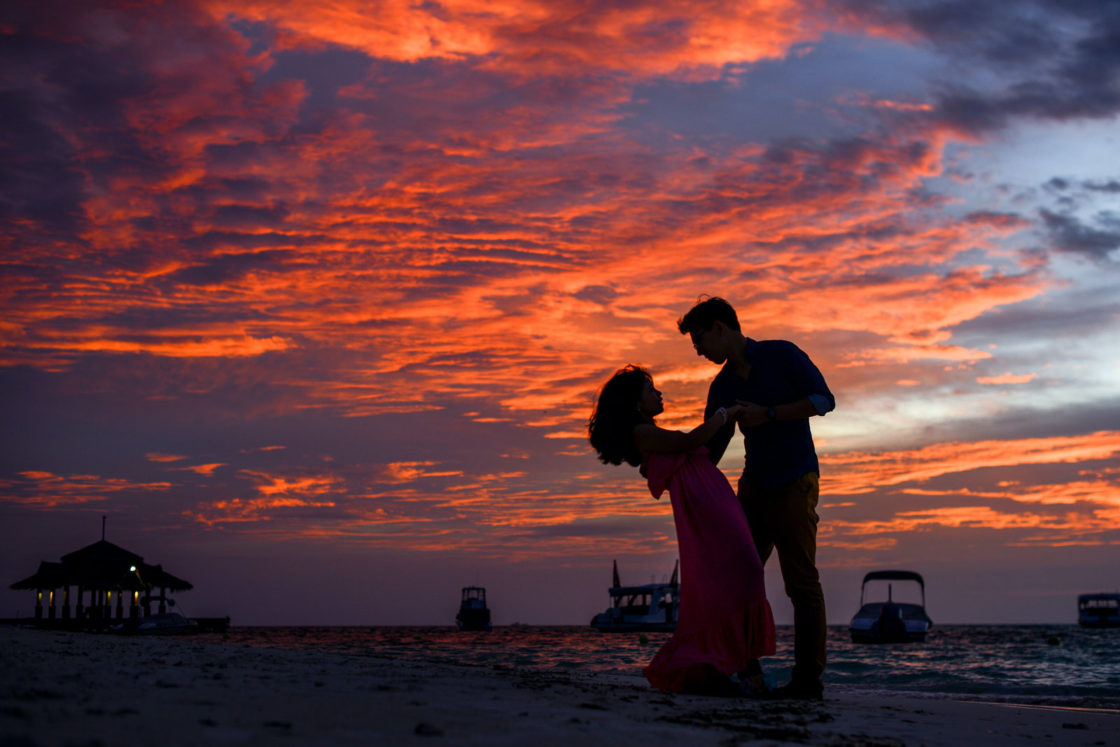 woman and man by the sea shore at sunset