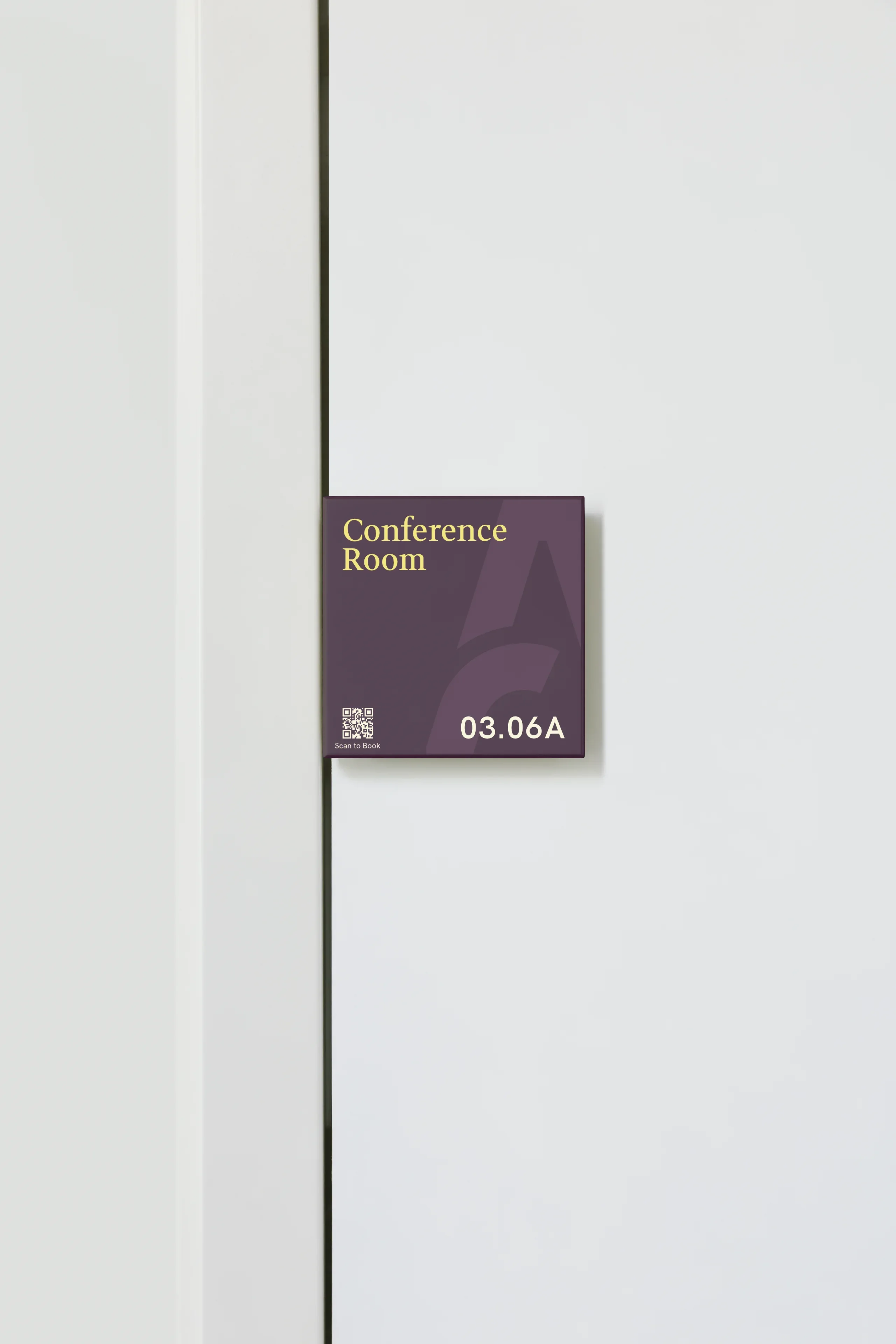 Purple conference room door sign with yellow text 03.06A and a small QR code.