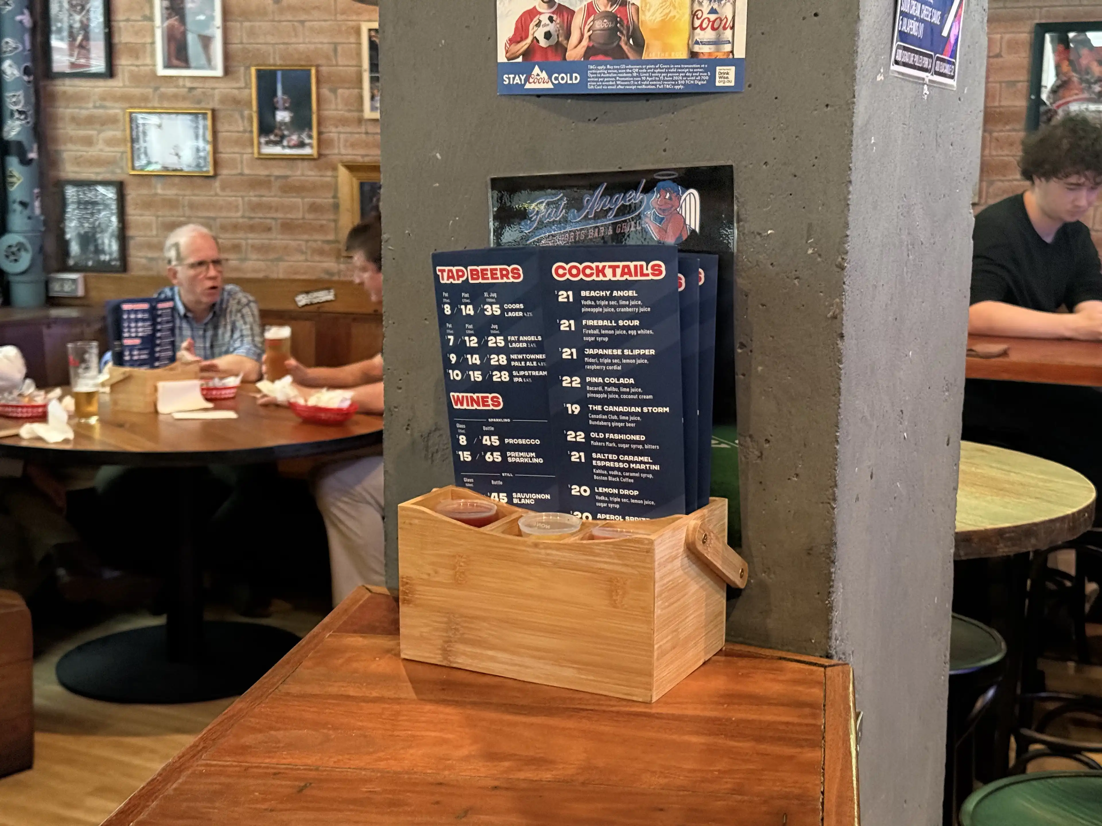 A photo of the Fat Angel Sports Bar and Grill menu in a table holder.