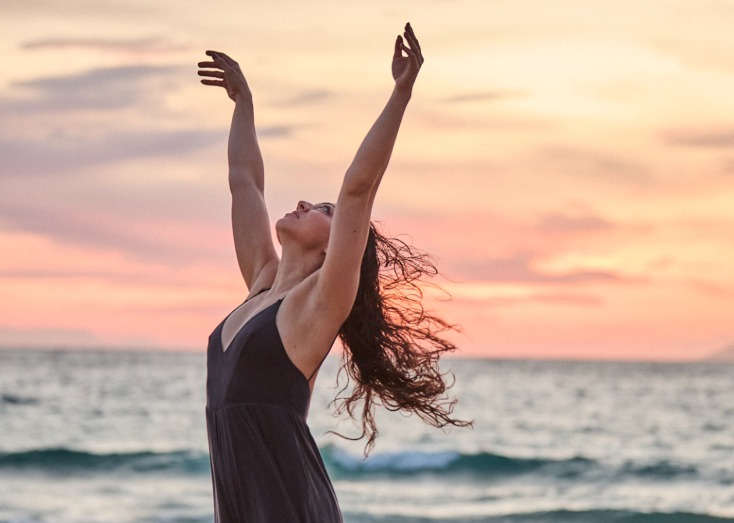 Image of Qayyah in a yoga posture on a beach in Paros at sunrise