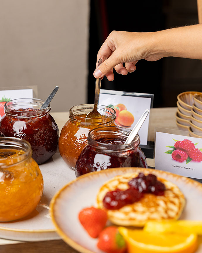A dining table with pink chairs in the back room