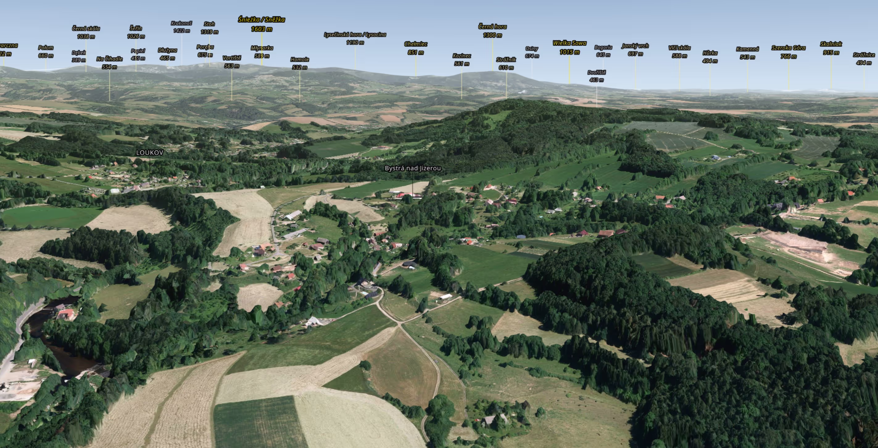 3D letecký pohled na vesnici Loukov a Bystřá nad Jizerou obklopenou poli, lesy a kopci s popisky hor a jejich výškou v pozadí.