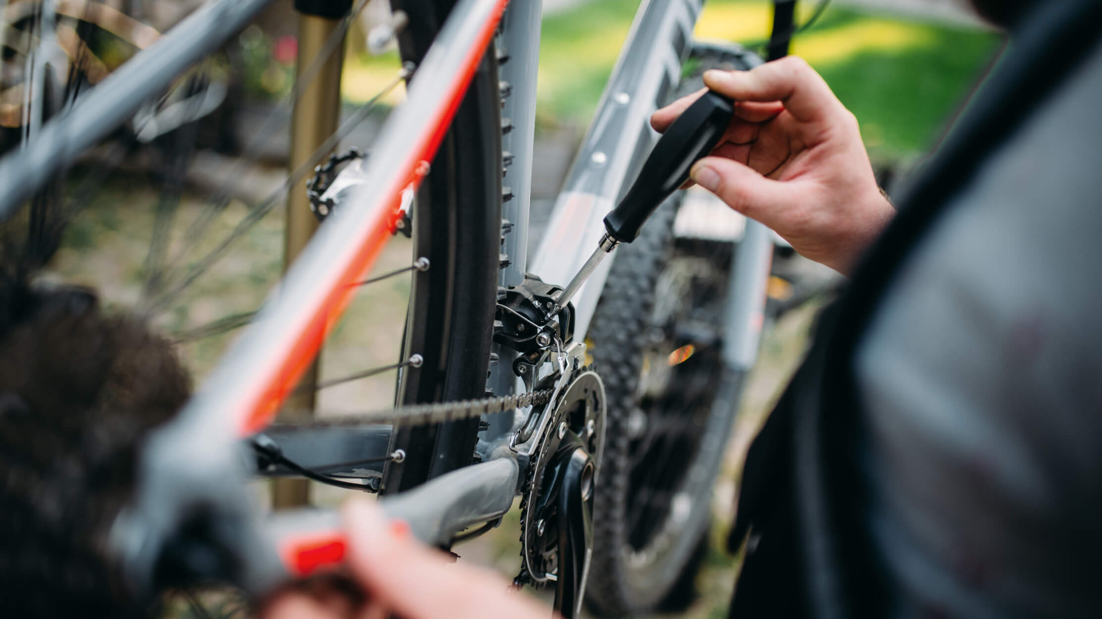 En cykelsmed justerer gearene på en moderne mountainbike. Præcisionsarbejde med det rette værktøj i brug.