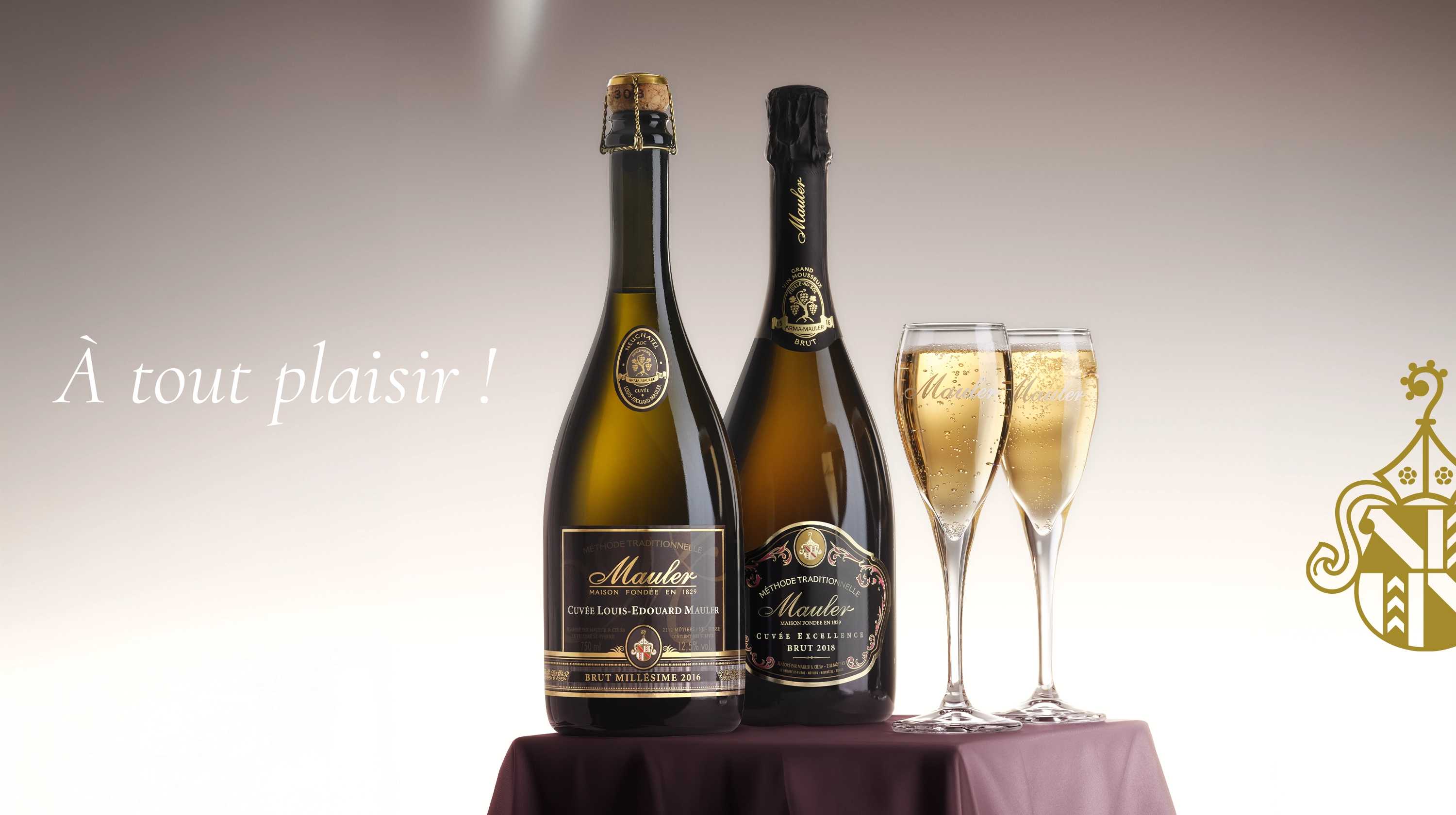 Deux bouteilles de Champagne Mauler et deux flûtes remplies de vin mousseux sur une table.