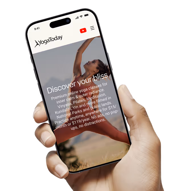 Hand holding a smartphone displaying YogaToday website with a woman doing a yoga pose and text about premium online yoga classes.