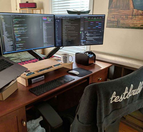 Focused home office workspace with double monitors and art in the background