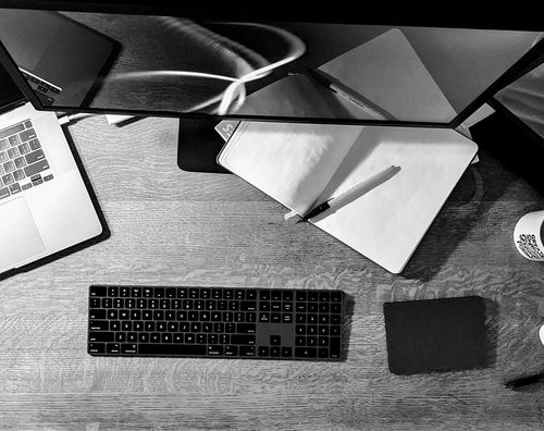 Black and white art photo of a well-used remote workspace