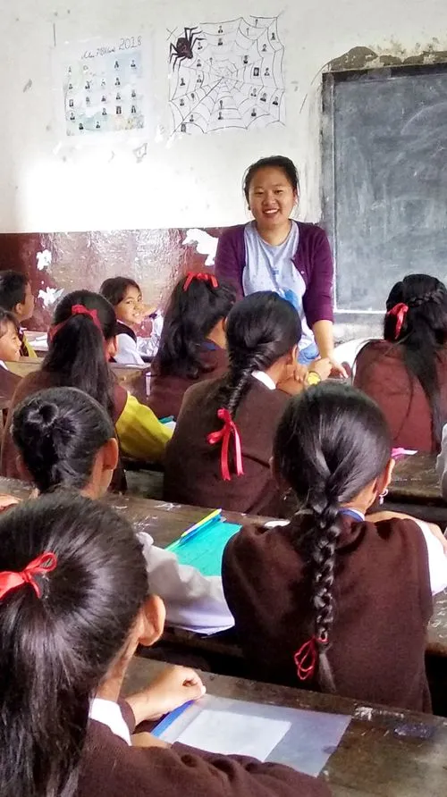 A lady teaching a classroom full of girls