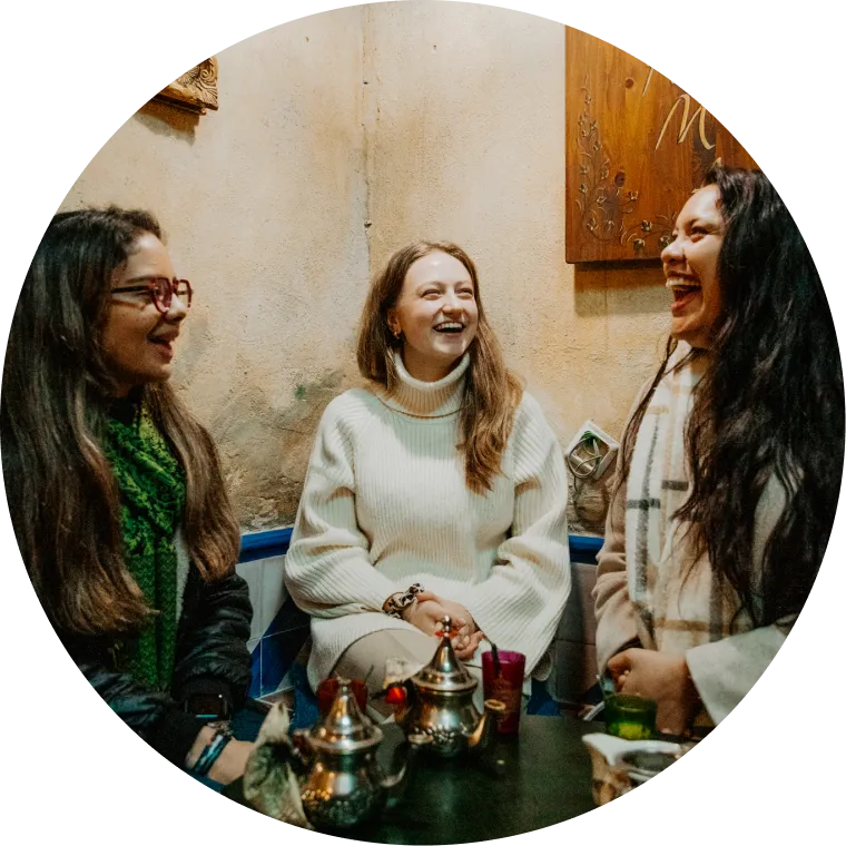 Three Mesa Interns sitting around a table laughing.