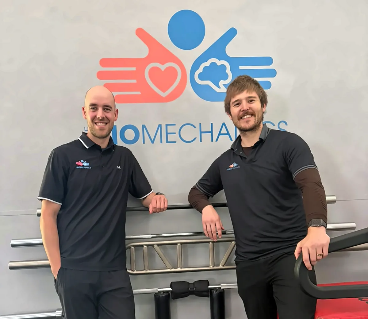 Two of our Port Melbourne team in front of the clinic logo