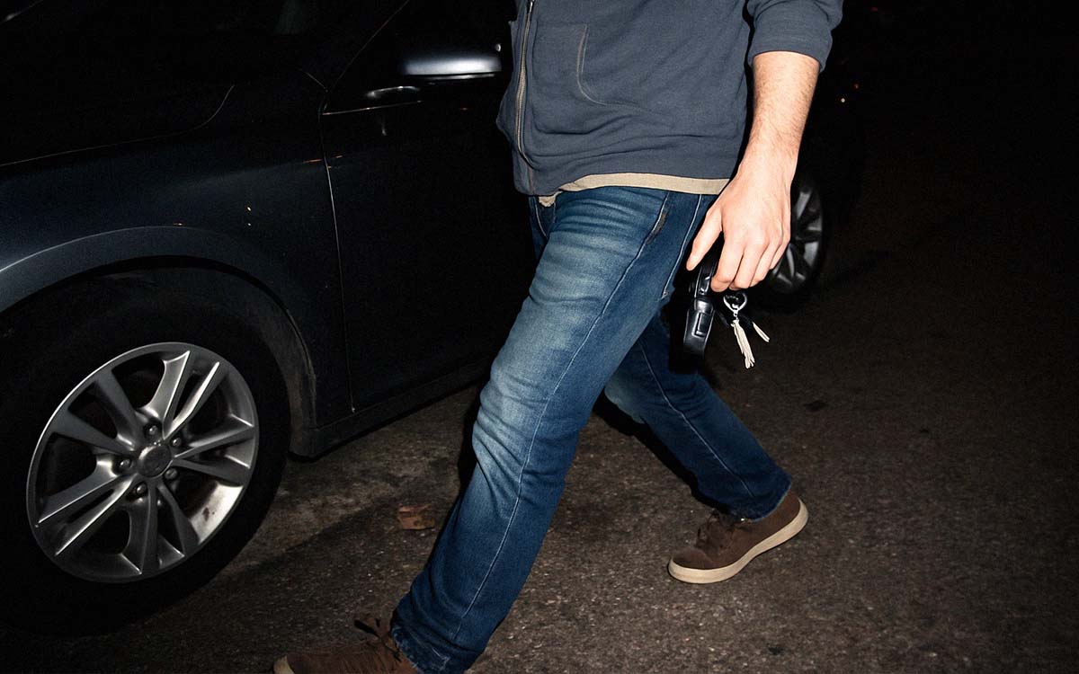 Person som promenerar mot sin bil med nycklarna i handen.