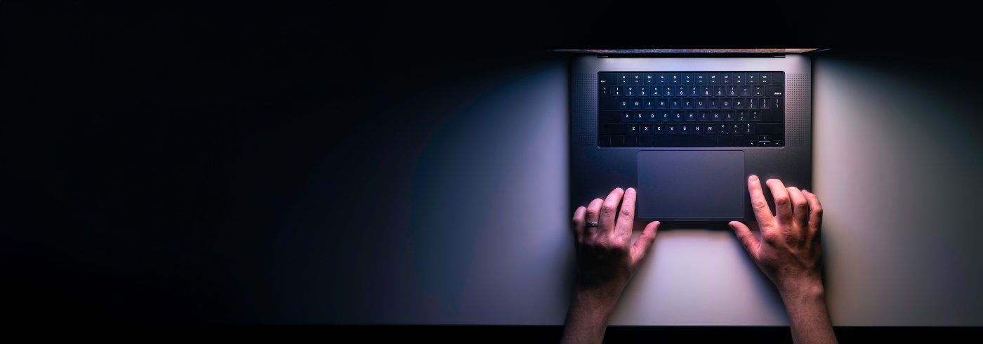 Laptop von oben auf dunklem Schreibtisch bei Nacht