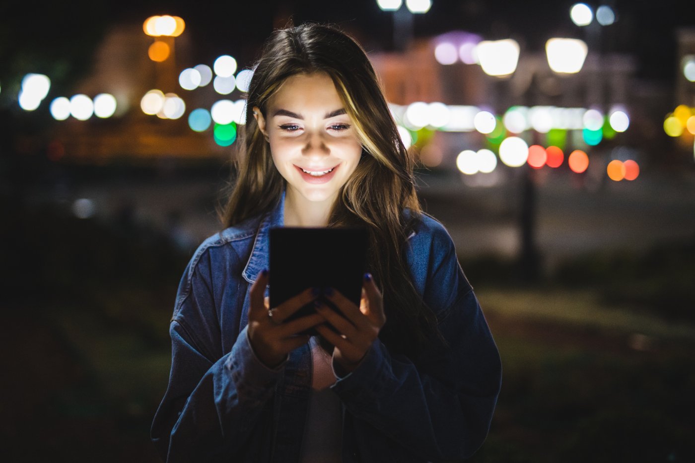 Person sucht abends unterwegs auf einem Tablet nach einem lokalen Anbieter