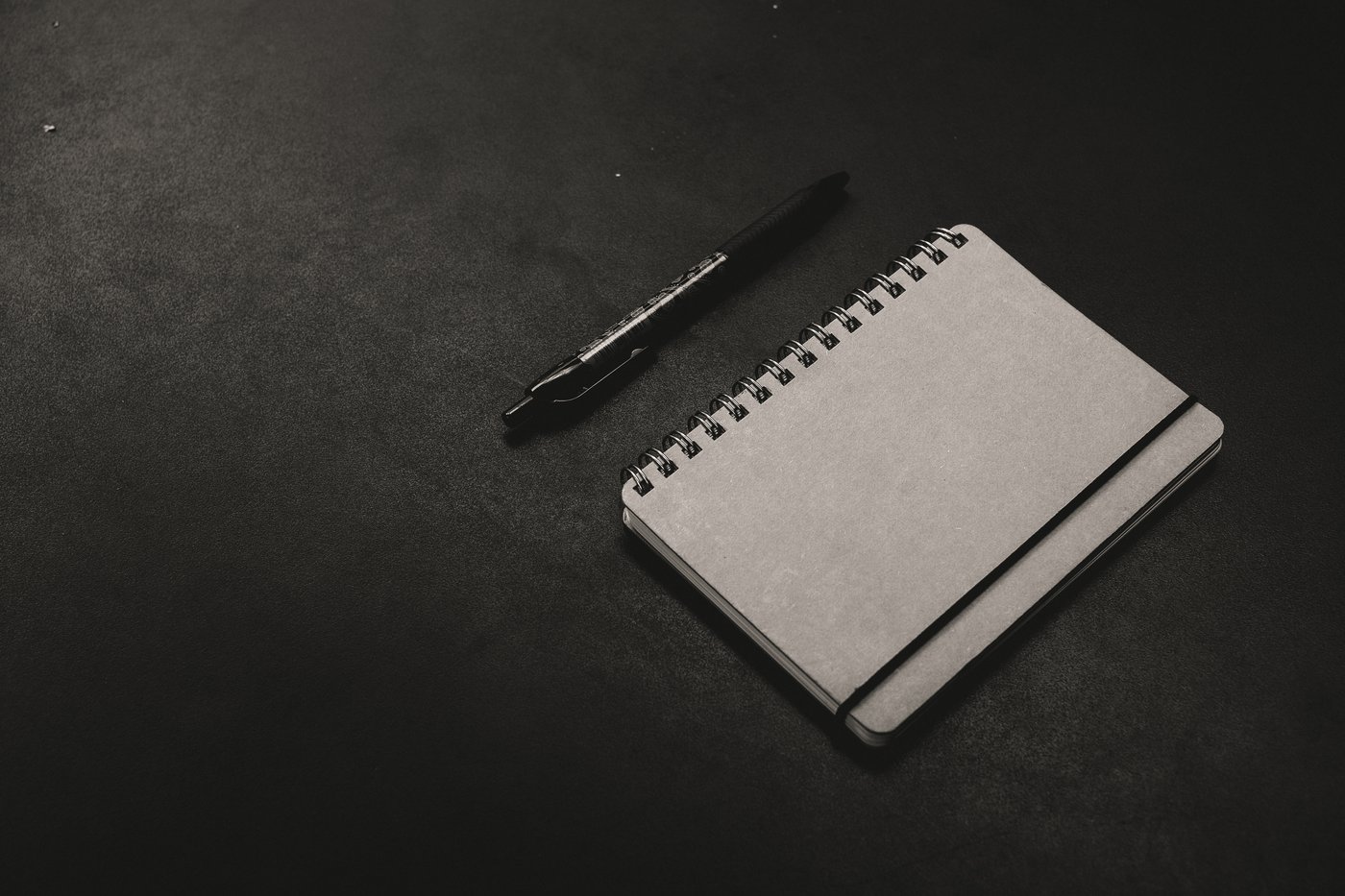 Notizblock und Stift auf einem dunklen Tisch bei der Auswertung von Suchanfragen