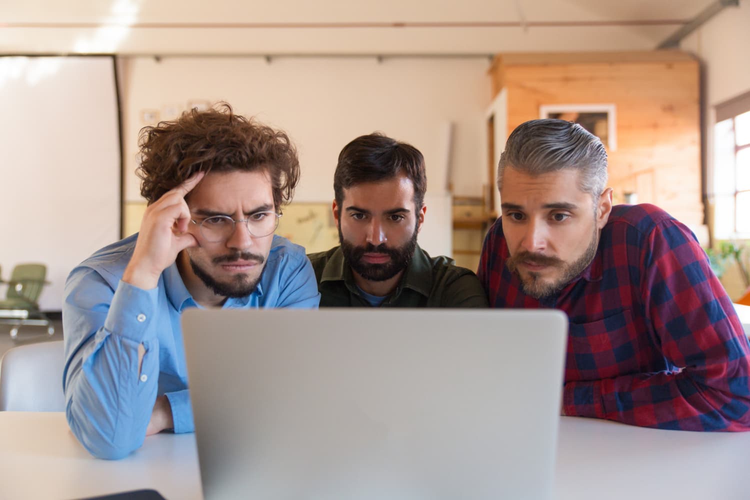 Person arbeitet abends im dunklen Büro am Laptop an einem Website-Projekt