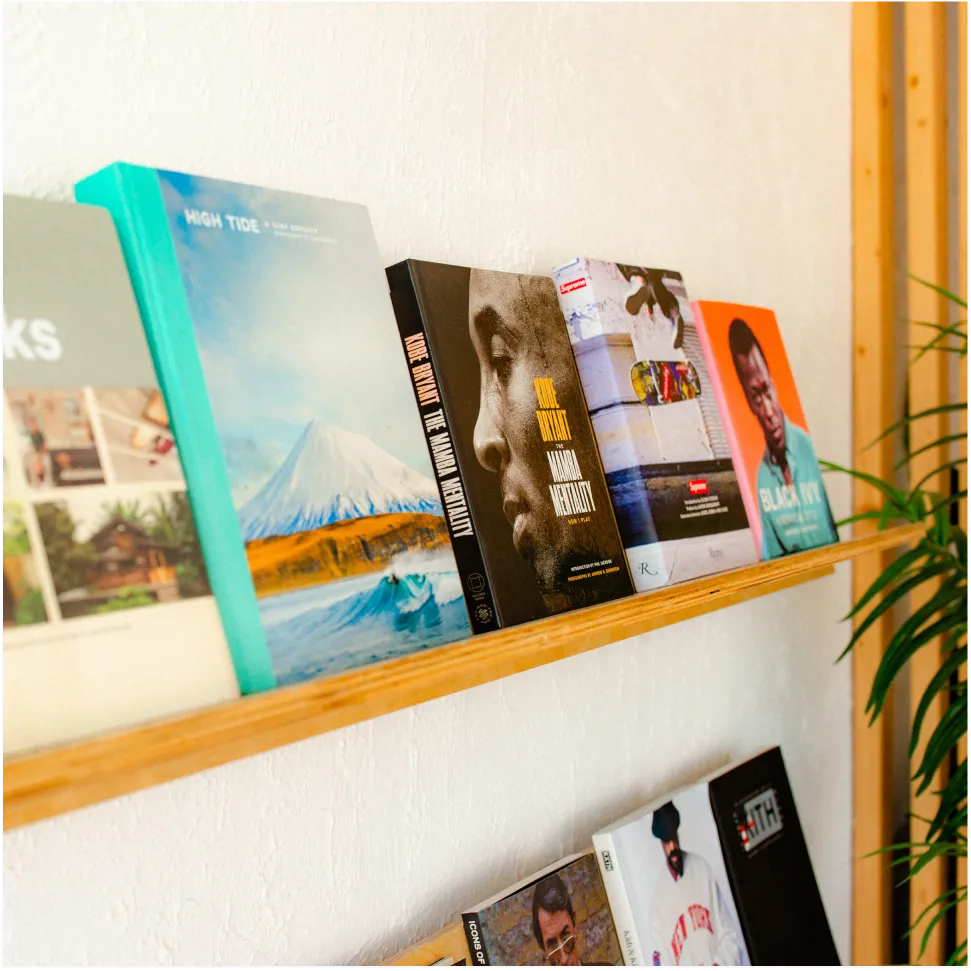 Curated books and magazines displayed on a wall shelf inside a neighborhood barbershop studio in Lakeland, Florida