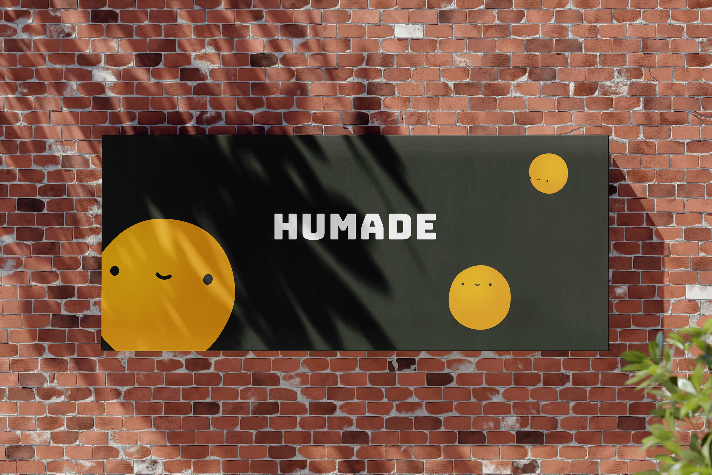 Photo of a HUMADE billboard on a brick wall.