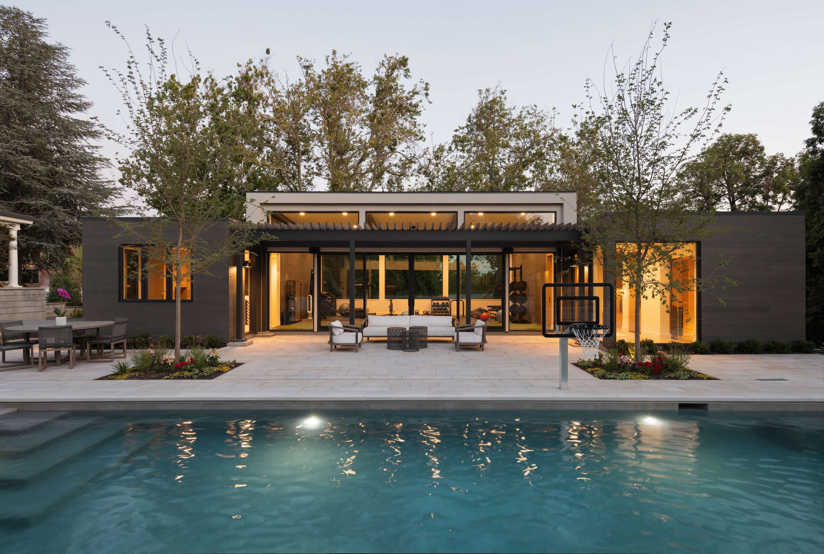 Evening shot of pool and poolhouse built by Living Home Construction