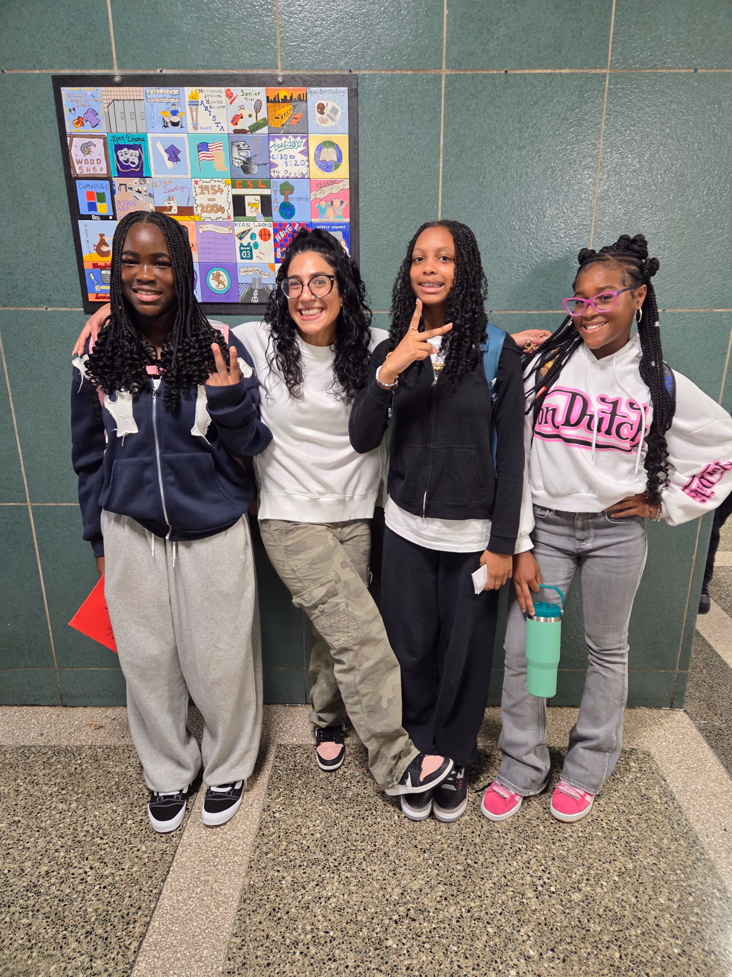 Four students standing together on educational floor mat