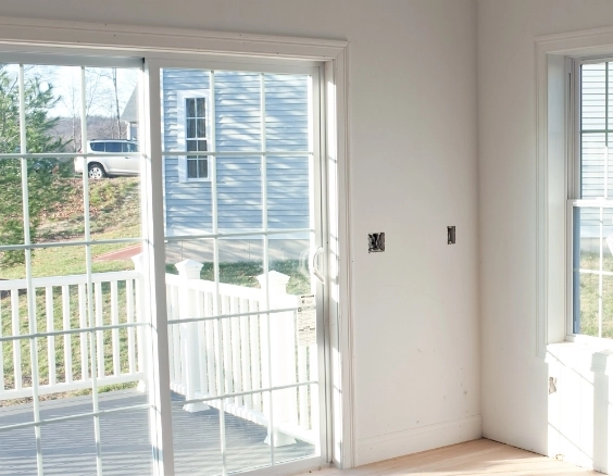 Alarmed and shatterproof window in Flatrock resident home, featuring secure sliding glass door to outdoor deck for safety and accessibility in care plans.
