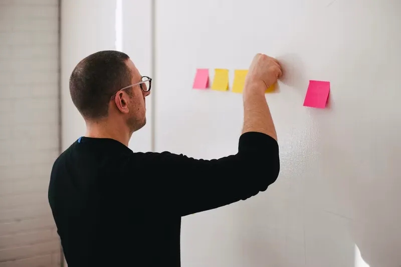 A man put sticky notes in wall