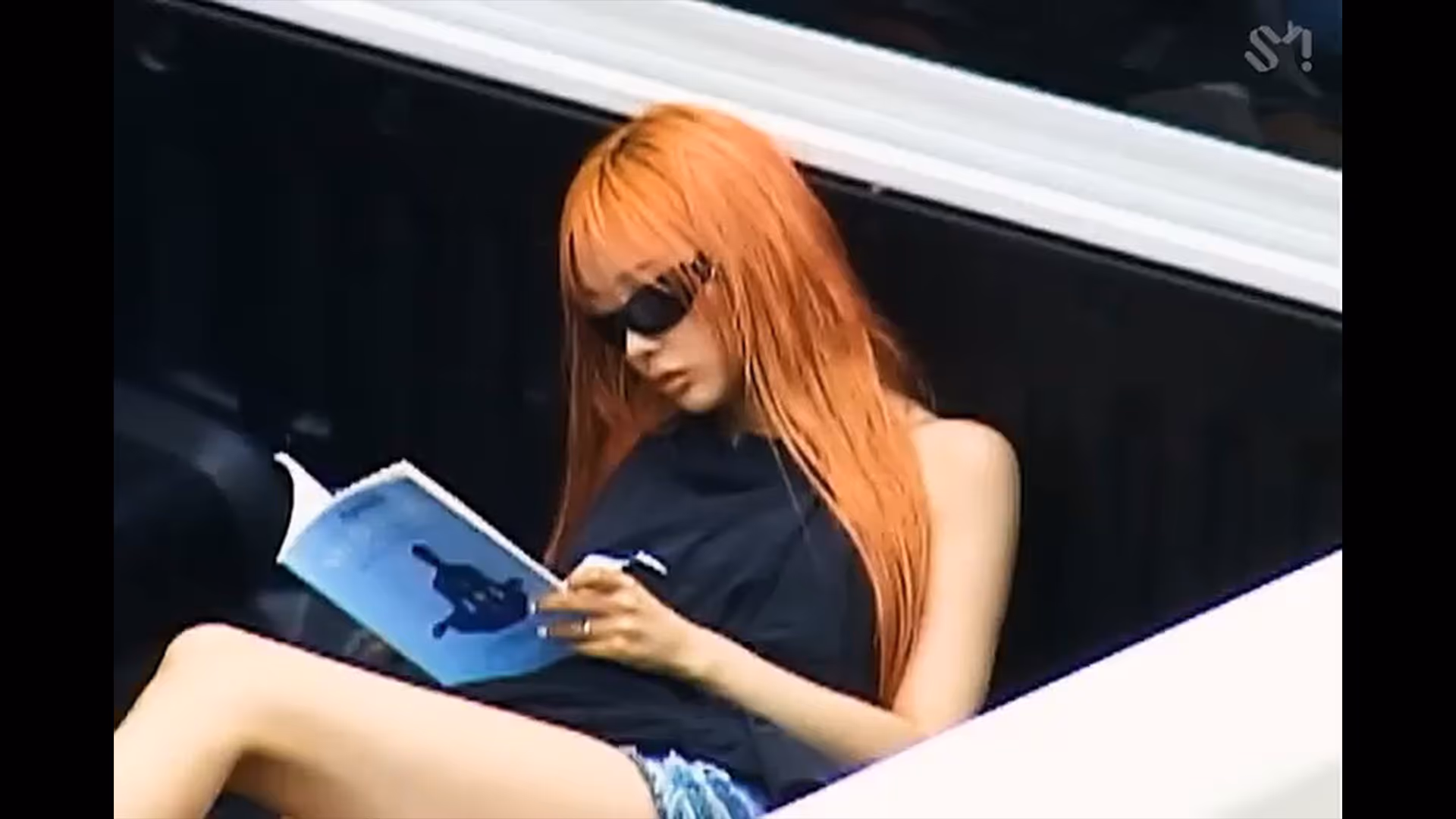 트럭의 트렁크 위에 앉아 책을 읽는 에스파 멤버 지젤 / GISELLE, a member of aespa, sitting on a truck trunk and reading a book

