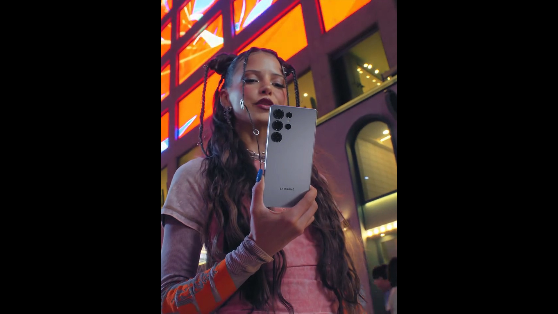 어두운 밤, 홍대 거리에서 갤럭시 S25를 바라보는 독일 아티스트 Nina Chuba의 모습 / German artist Nina Chuba looking at the Galaxy S25 on the streets of Hongdae at night