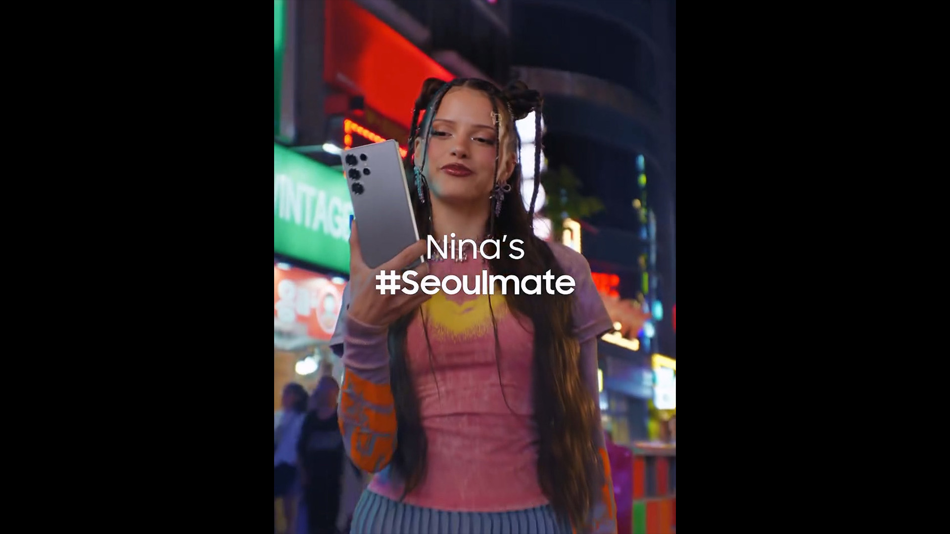 Nina Chuba standing on the streets of Hongdae holding a Samsung Galaxy S25 Ultra, with white text "Nina's #Seoulmate" displayed above.