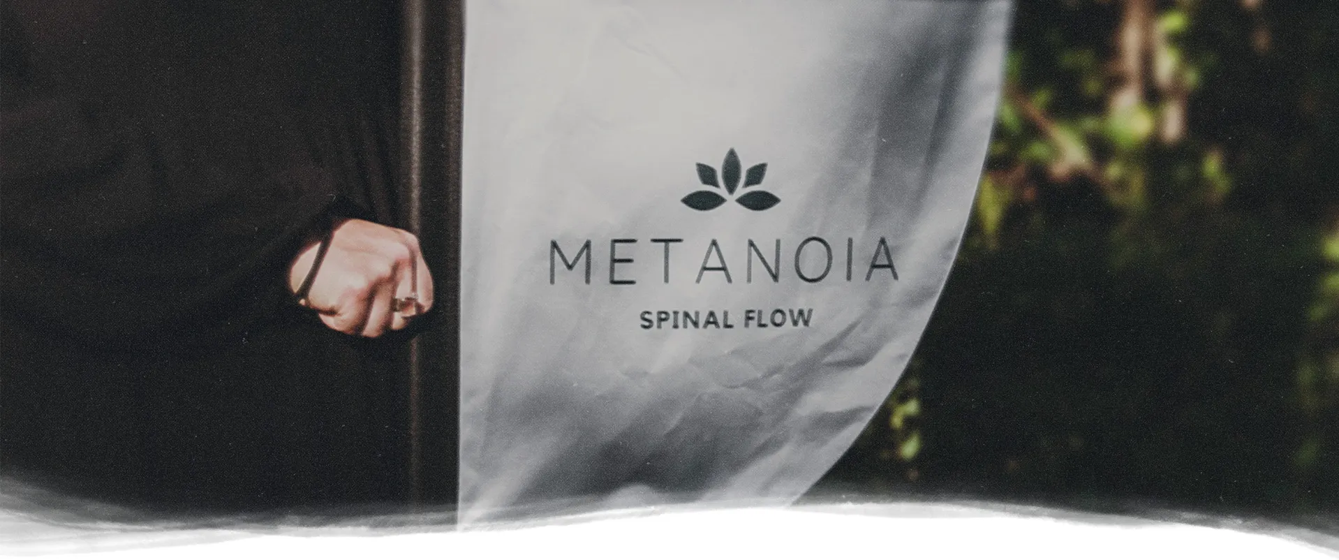 a glass or acrylic panel with the text "Metanoia Spinal Flow"
