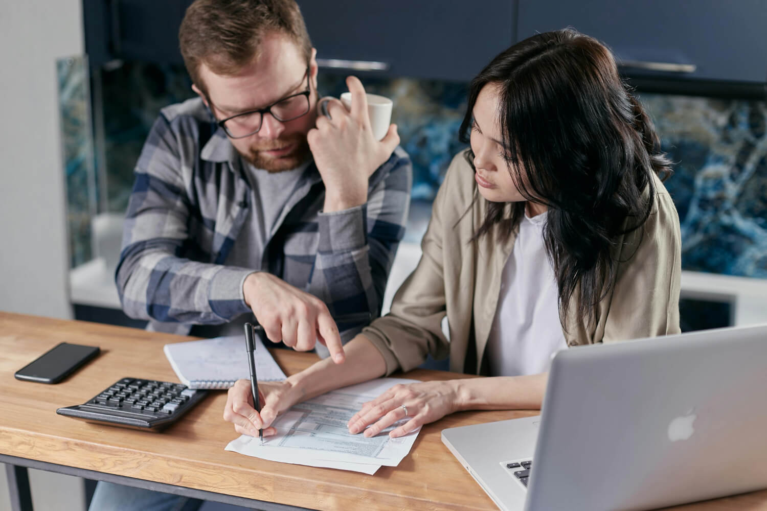 Business partners are reviewing financial documents to bridge a cash flow gap.