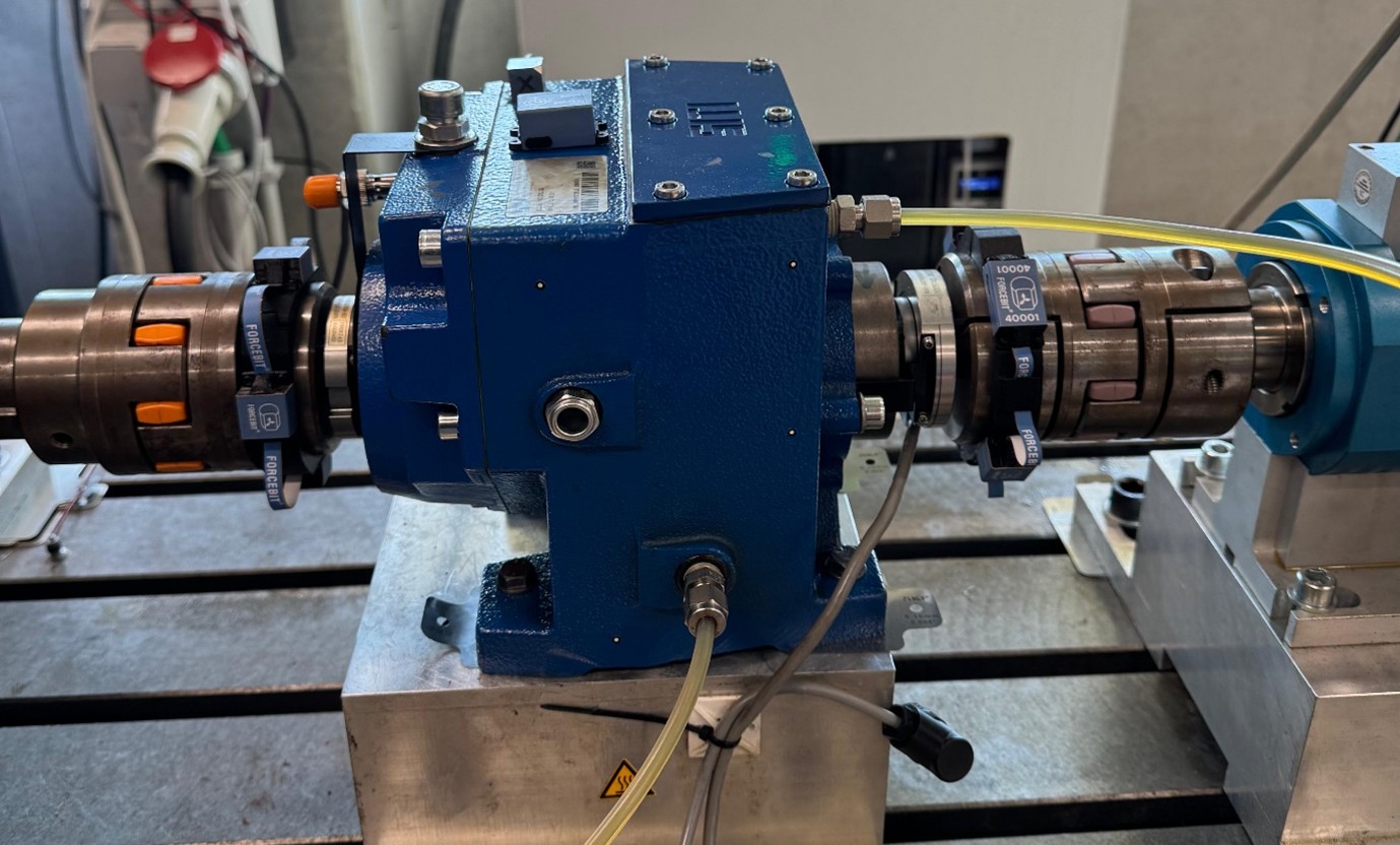 Wireless angular encoders from Forcebit clamped on the input and output shafts of a blue gearbox on the LMSD testbench.