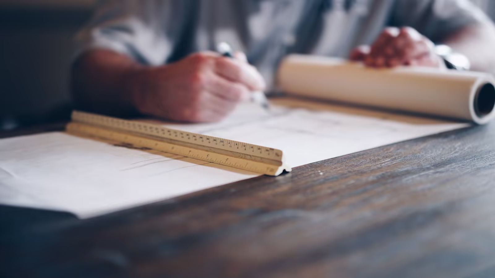 Two engineers rereading together a plan produced by an assistant