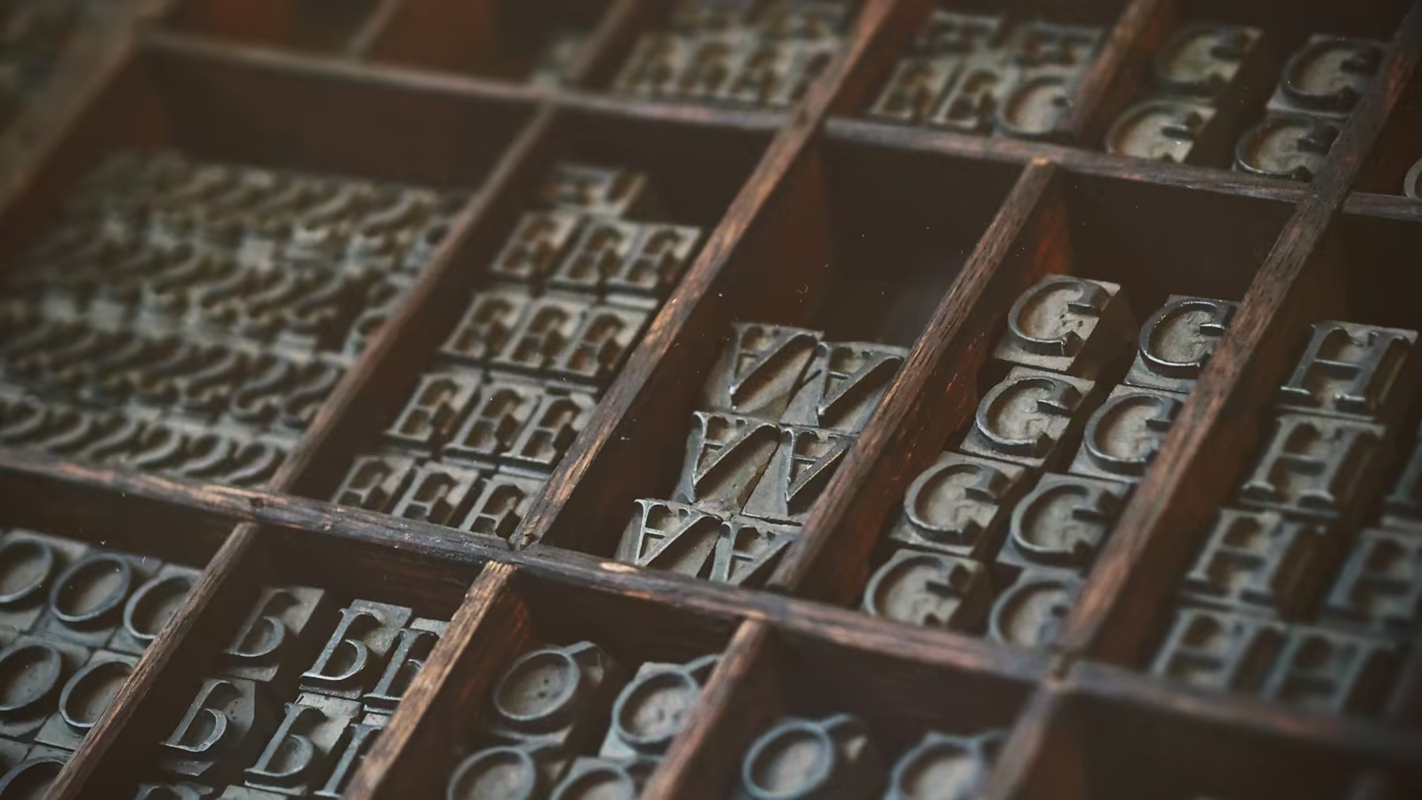 A typographer carefully composing a name with metal letters
