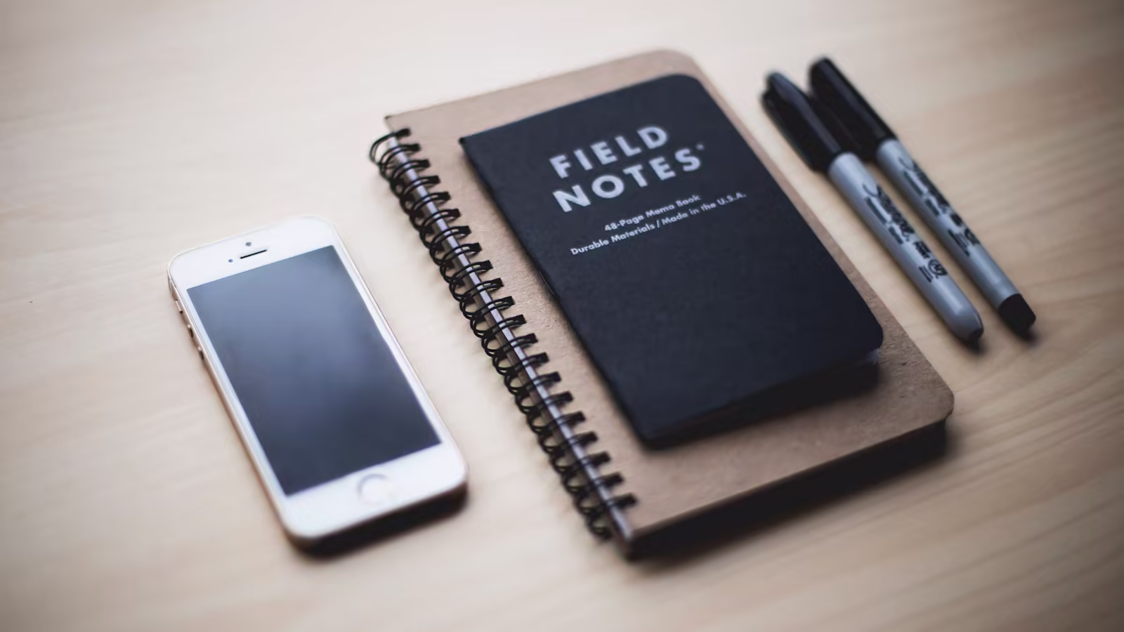 A research notebook accompanied by simple prototypes on a table