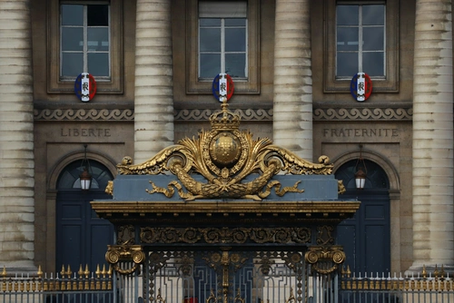 Fachada monumental de París con columnas doradas, ventanas y adornos.