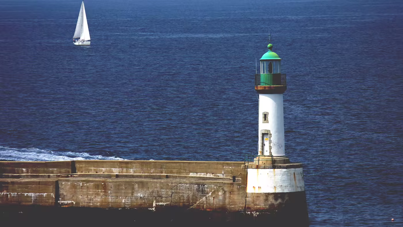 Un phare protégeant un port tandis que des routes partent vers le large