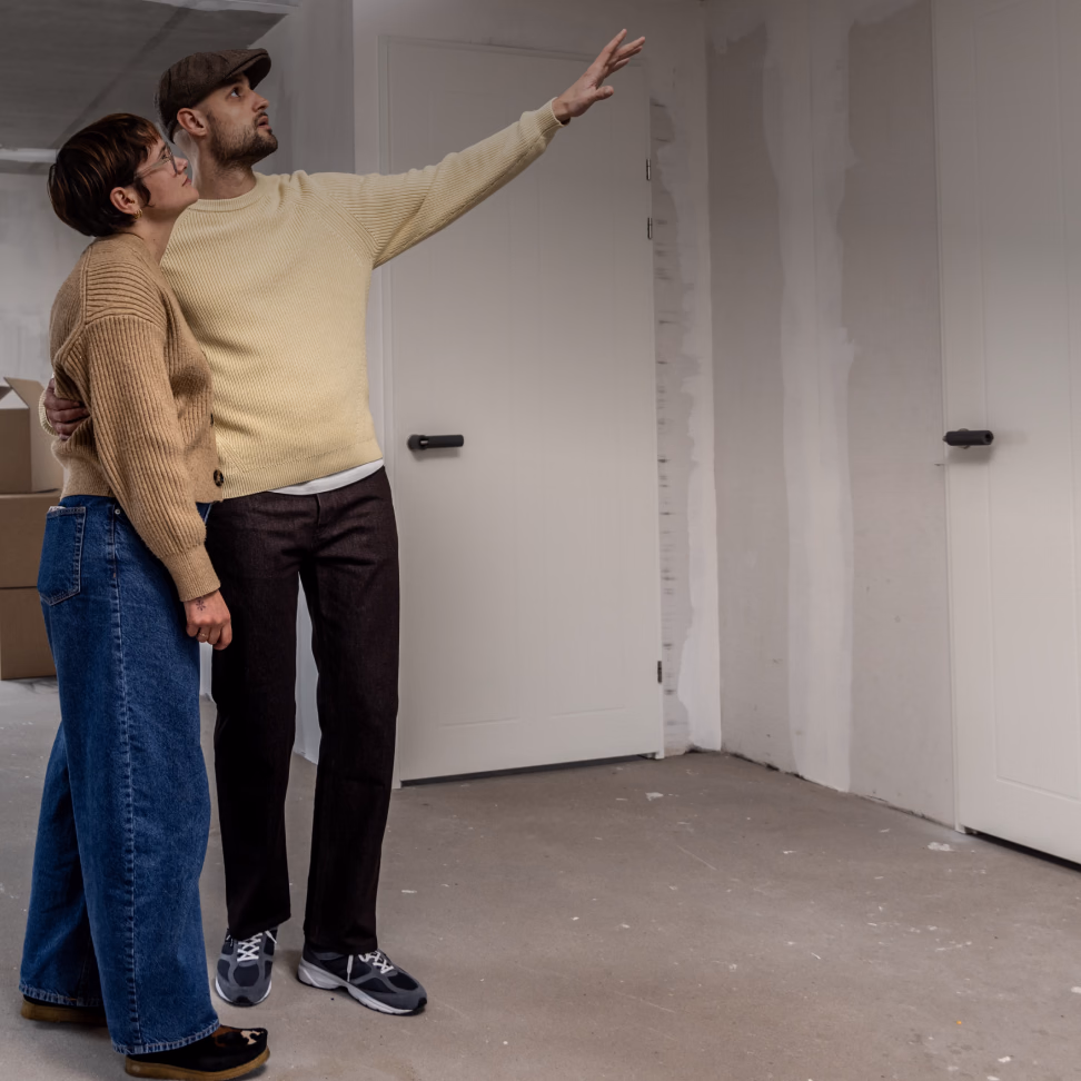 Couple viewing a property while a financial app shows an affordable monthly payment of up to €1,000.