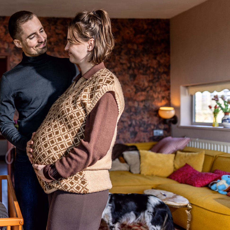 Expectant couple reviewing a budgeting app prediction about the financial impact of having a child.