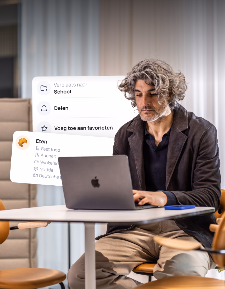 Man with curly hair using laptop with menu overlay showing School, Share, Add to favorites, and Eten options