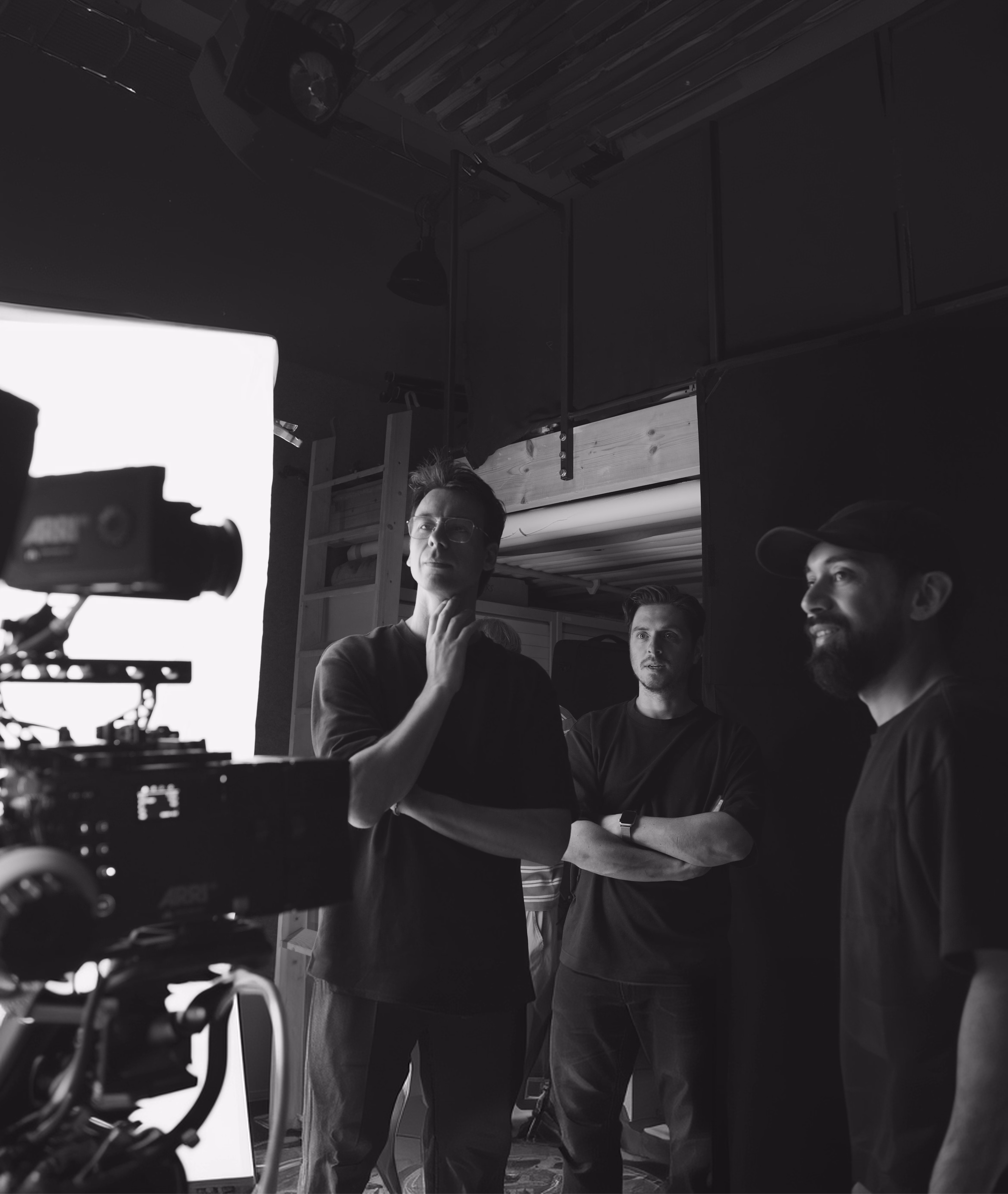Four people working together in a dark film or television production studio with professional equipment