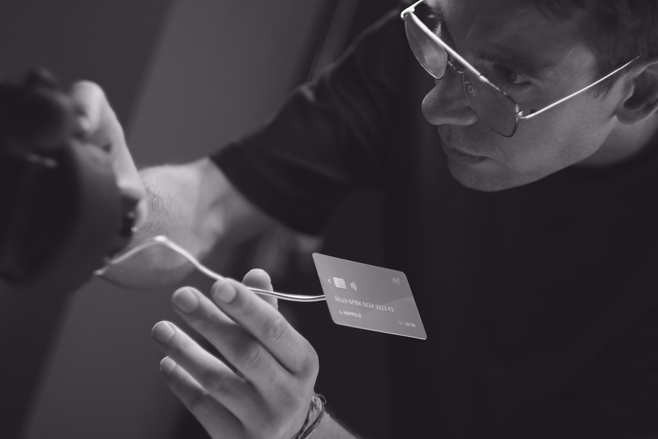 Person in sunglasses examining a business card in black and white lighting