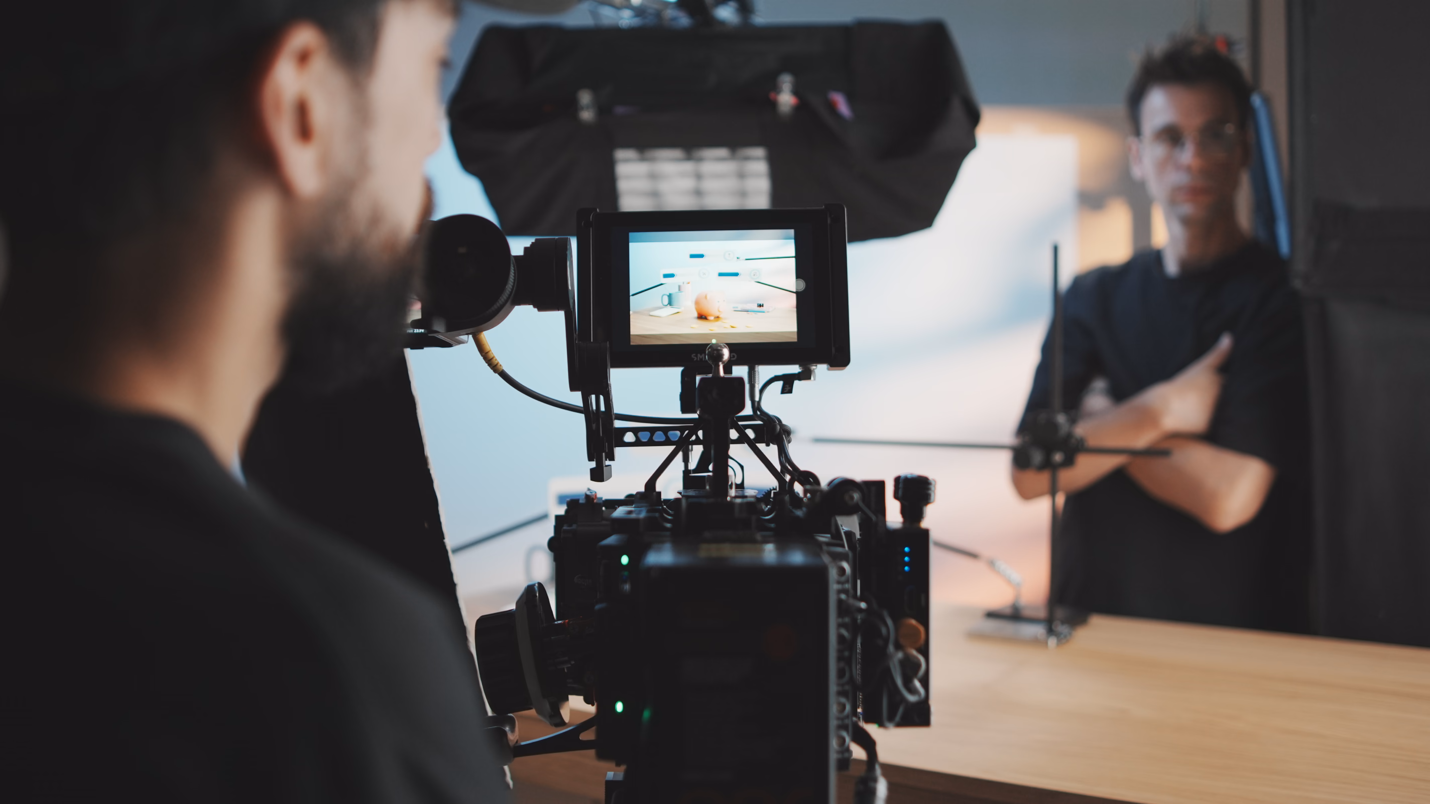 Professional video camera on tripod recording two people during an interview or filming session