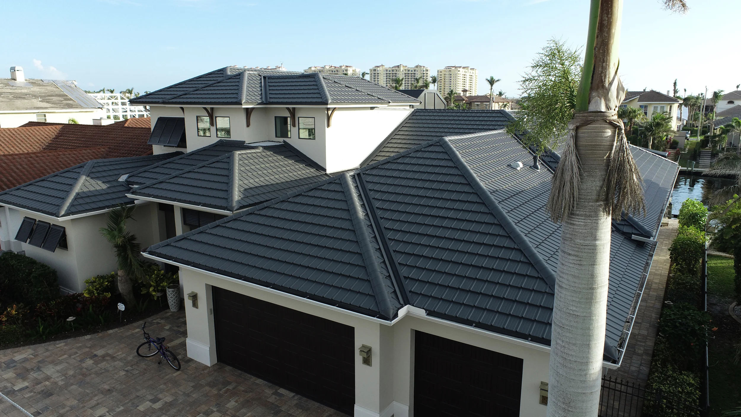 Photo of a white house with a gray metal tile roof